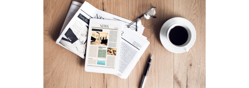 Benefits of publicity - tablet, newspaper, glasses, cup of coffee and pen all displayed on table